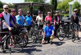group of people standing by their bikes smiling at camera
