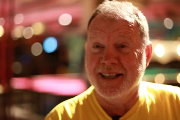 A man in a yellow tshirt smiling