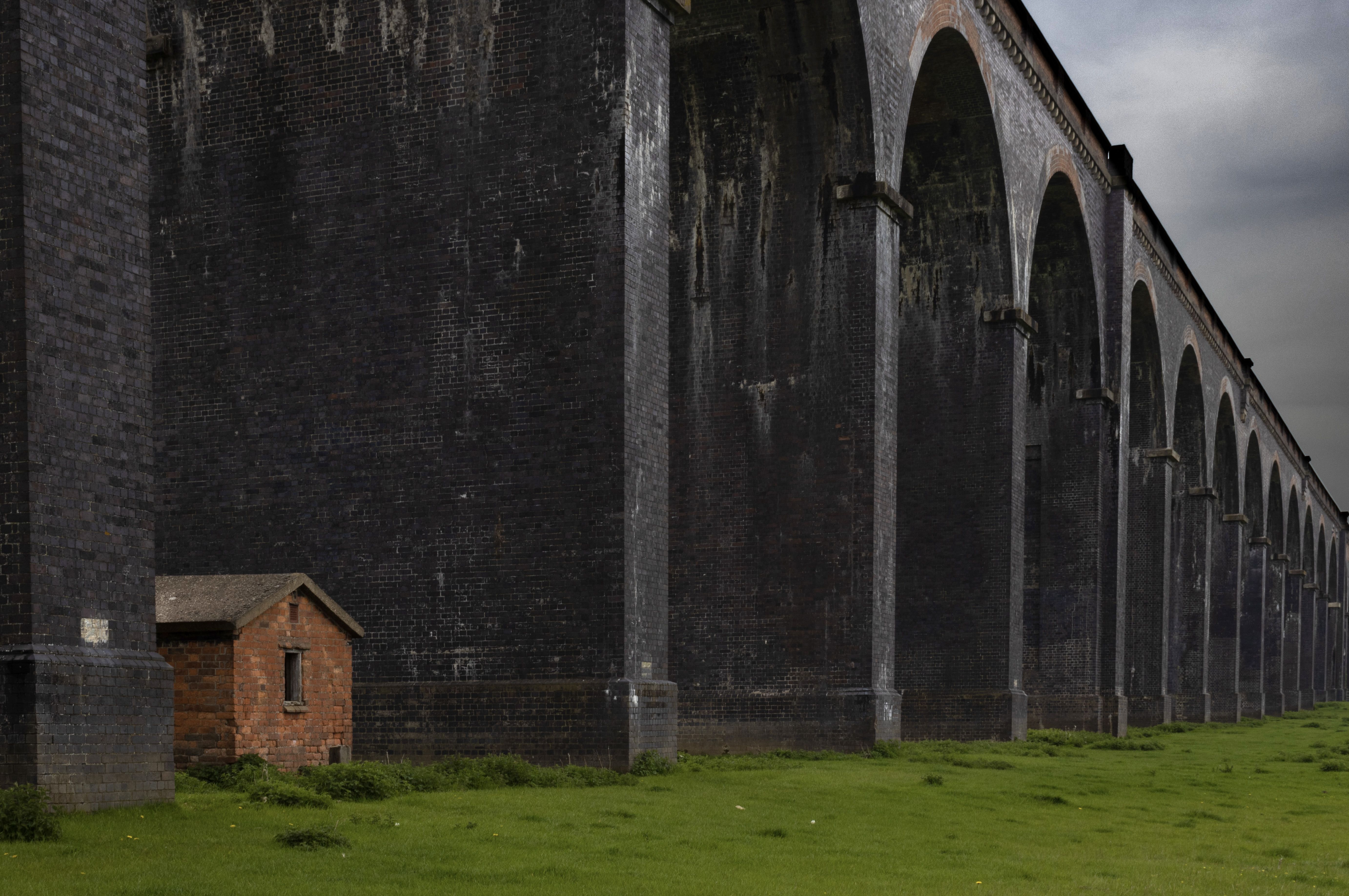 A small hut in between the huge brick arches of a railway viaduct