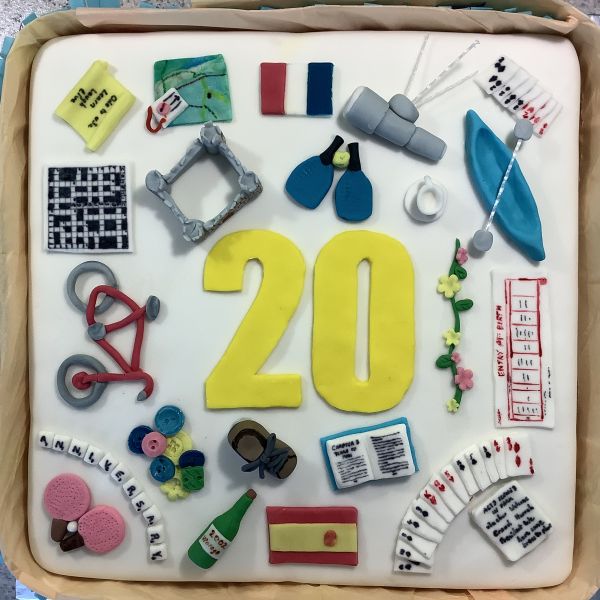 Square white cake decorated with colourful u3a activities in icing