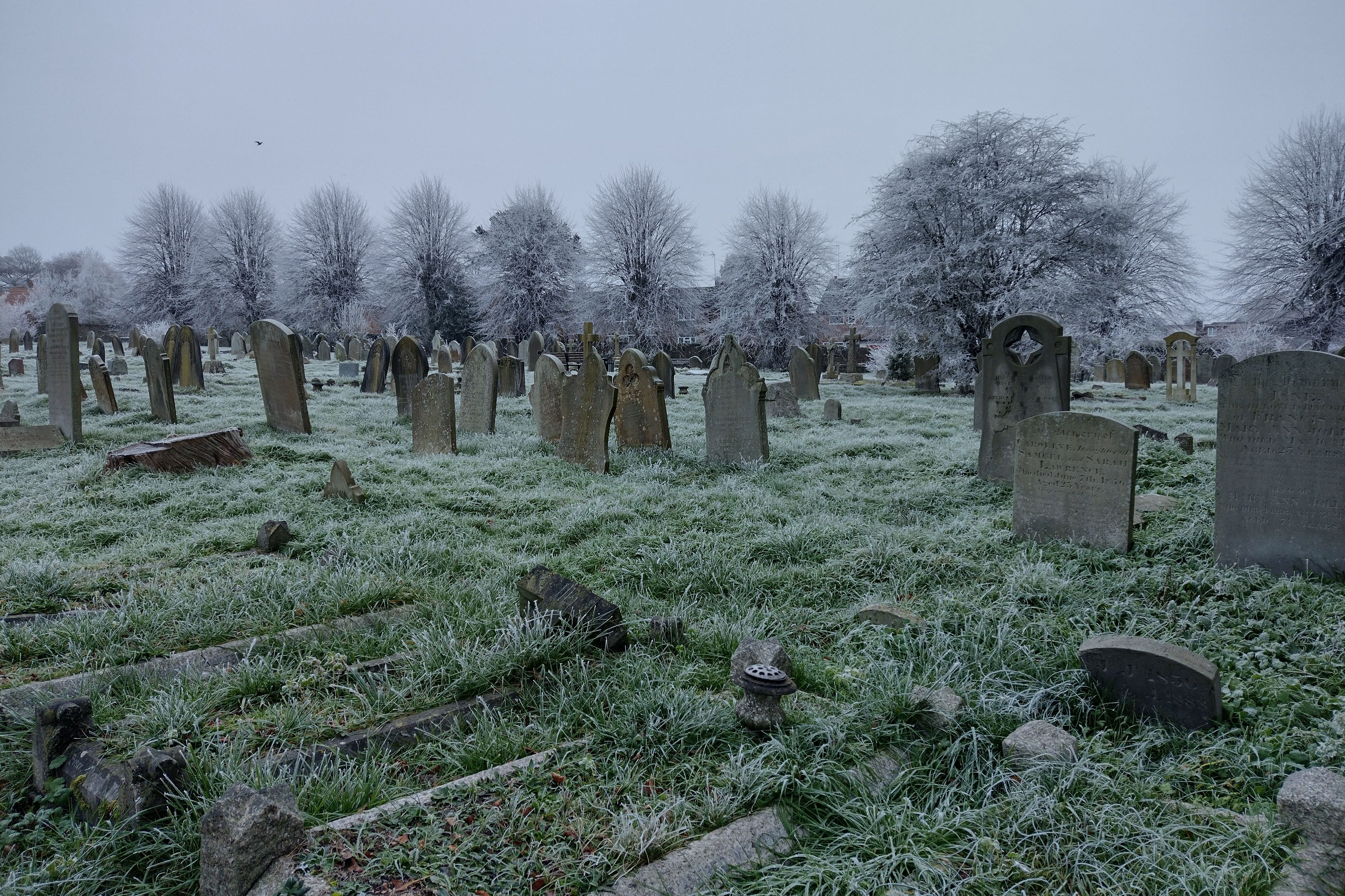 a frosty cemetery, the graves are decaying