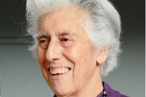 A woman in a purple top smiling