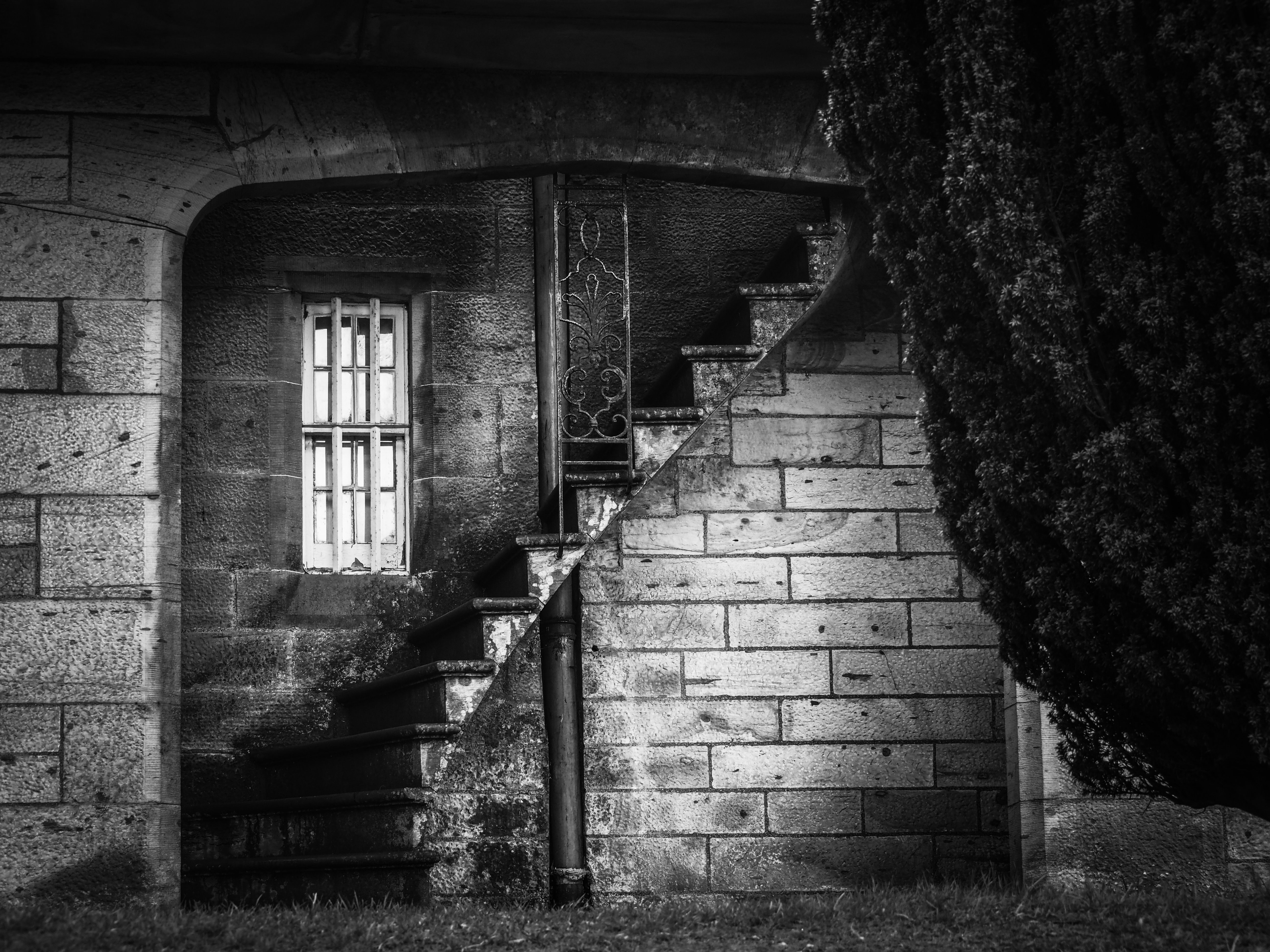 black and white photo of staircase in brick wall