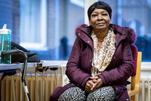 Woman wearing a purple jacket sitting on a chair