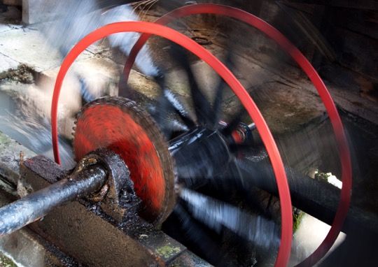 a red wheel spinning quickly with water rushing through it