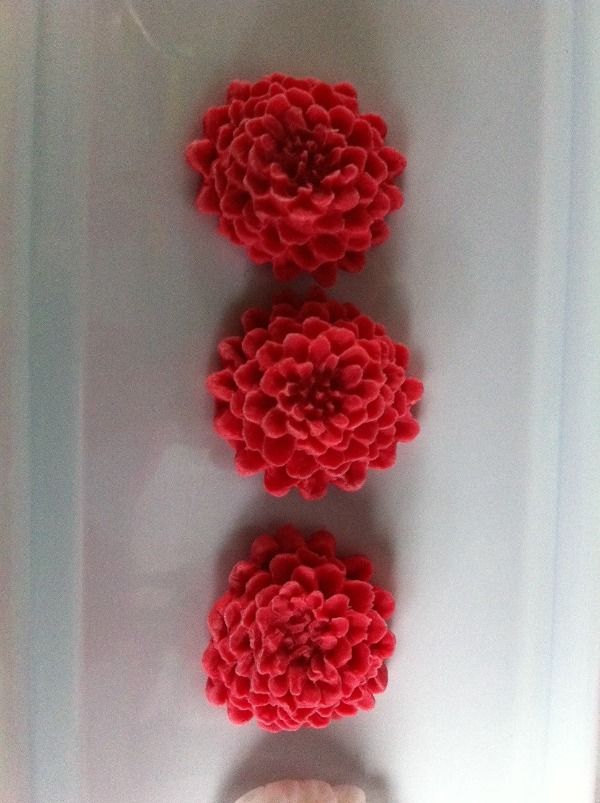 three intricate red flowers made of icing