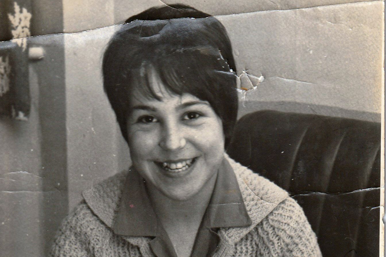 young girl with brown hair smiling at teh camera, photo is black and white