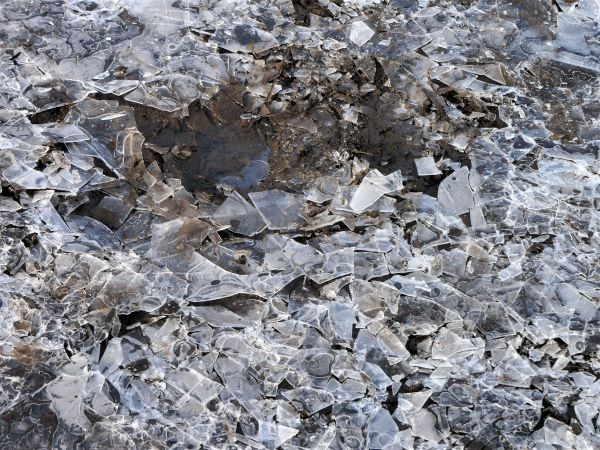 cracked ice in a puddle. mud beneath