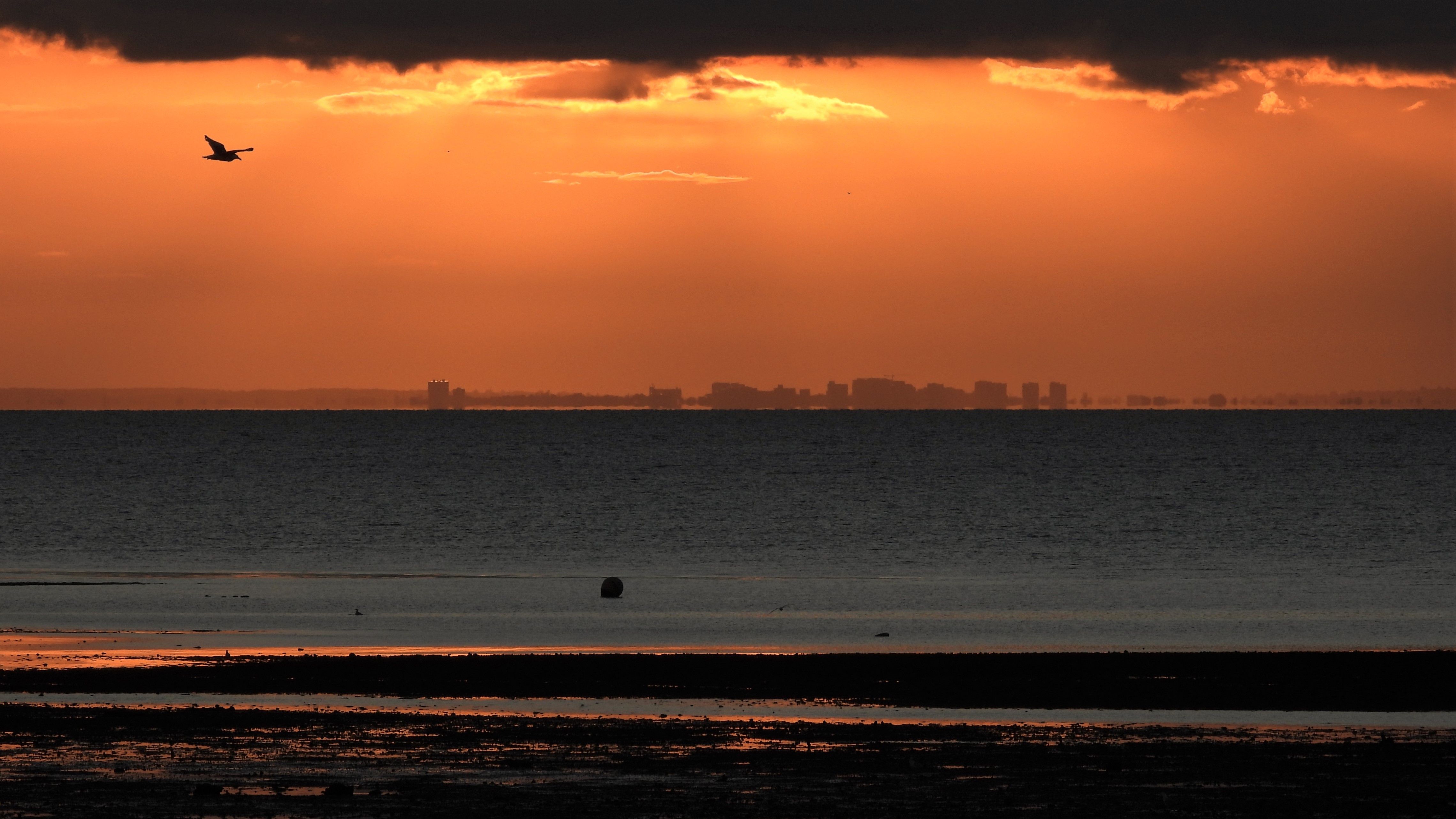 an orange sky sunset with dark blue sea 