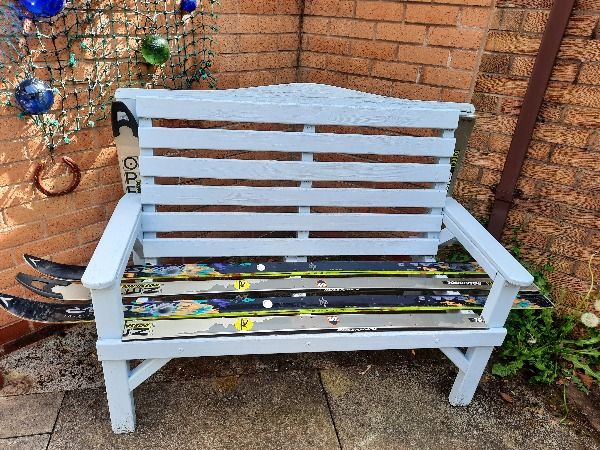 Pale blue bench with skis as planks