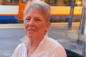 A woman in a white shirt sitting down