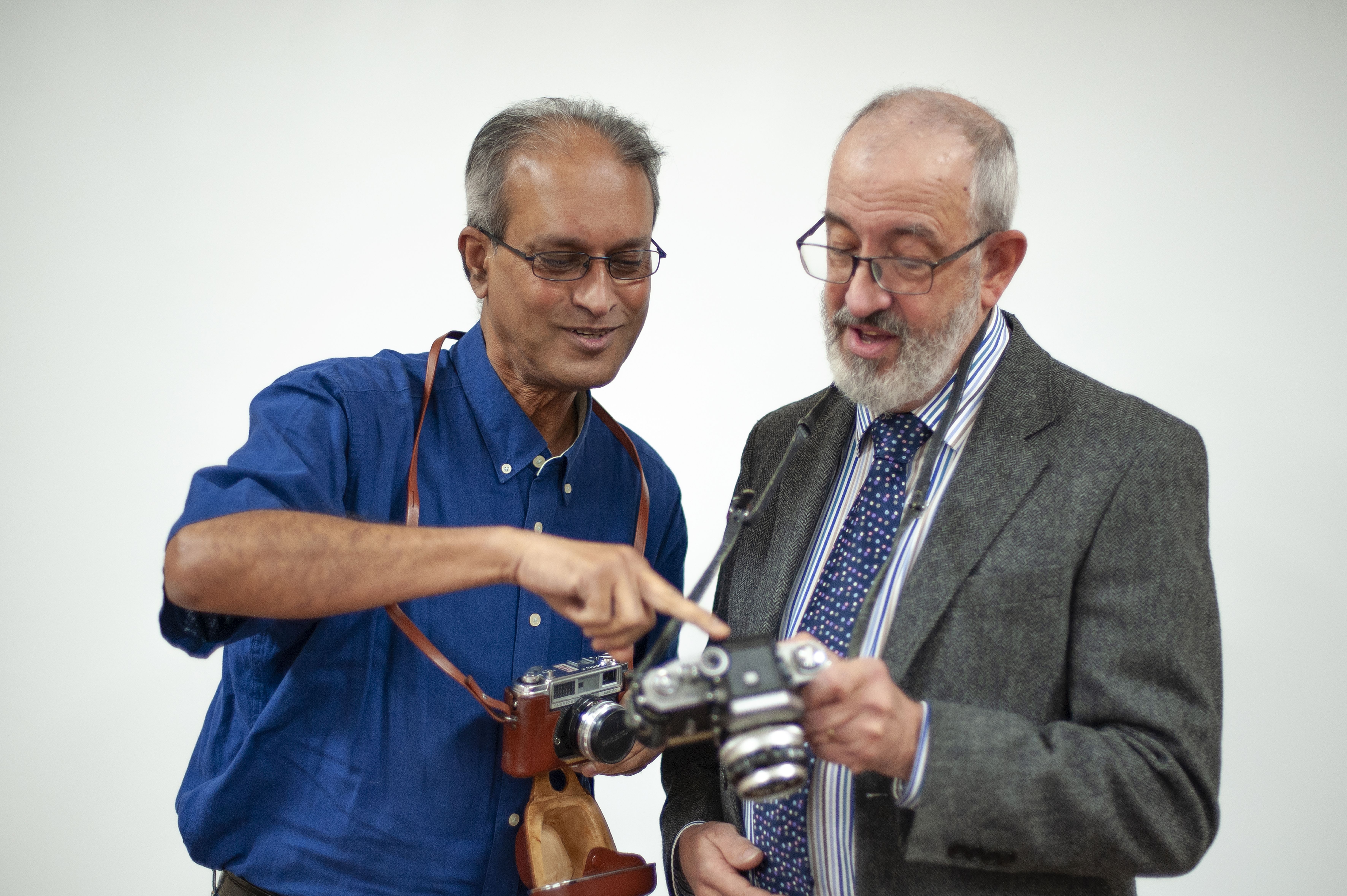 Two u3a members look at cameras and discuss their pictures